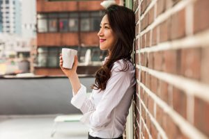 Woman smiling, delighted with her cup of coffee. 